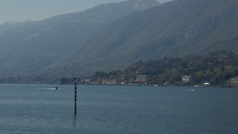 Ciudad-A-Orillas-Del-Lago-De-Bellagio-Con-Montañas-Boscosas-En-El-Fondo-En-El-Lago-Como,-Italia