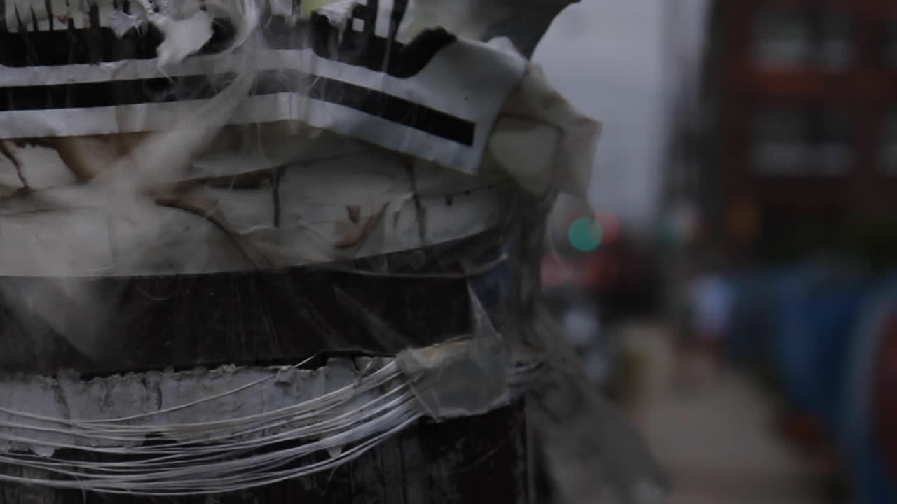Street Pole Covered in Torn Posters