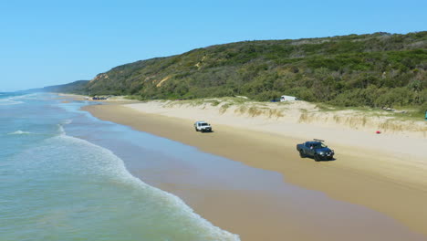 aerial view of cars driving along sandy cooloola