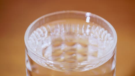 watch the serene beauty of water droplets creating ripples a glass symbolizing tranquility and clarity