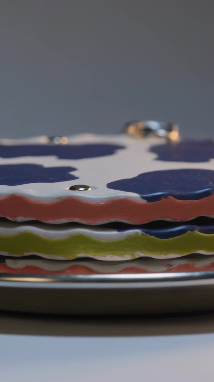Vertical video: Pulling camera revealing scalloped coral lime navy discs on tray, showing rivet