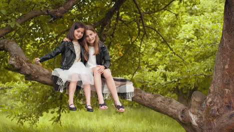 dos hermanas relajándose en un árbol
