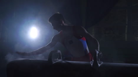 close - up of pommel horse on a dark background and smoke in slow motion male hands magnesia. preparation for the presentation