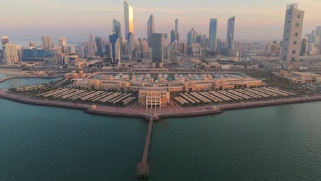 stunning 4k drone shot of marina crescent in kuwait with a golden sunrise over iconic skyscrapers and the waterfront. perfect for tourism, architecture, and cityscape themes.