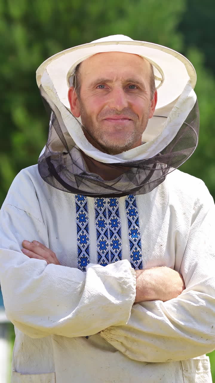 Beekeeper in protective workwear. Portrait of happy male beekeeper at apiary