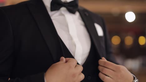 Handsome-groom-businessman-wearing-gray-jacket-indoors-at-barber-shop,-white-shirt-with-black-tie