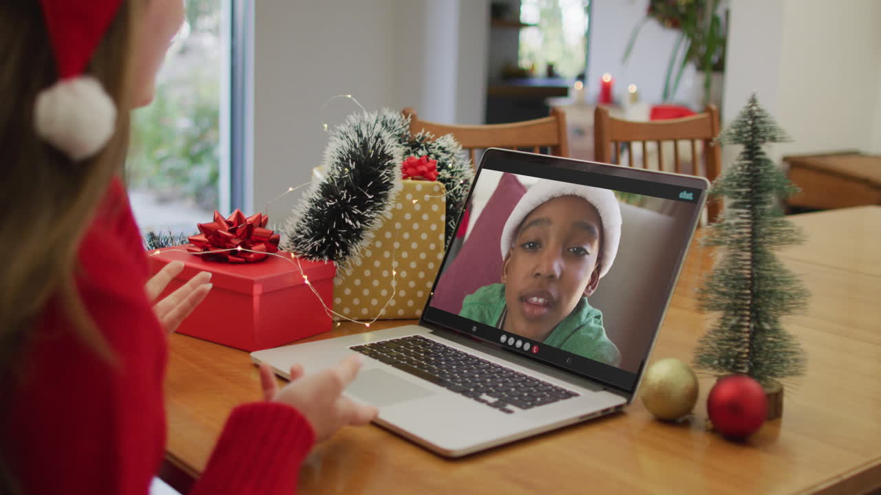 mujer caucásica feliz en videollamada con un niño afroamericano en tiempo de navidad
