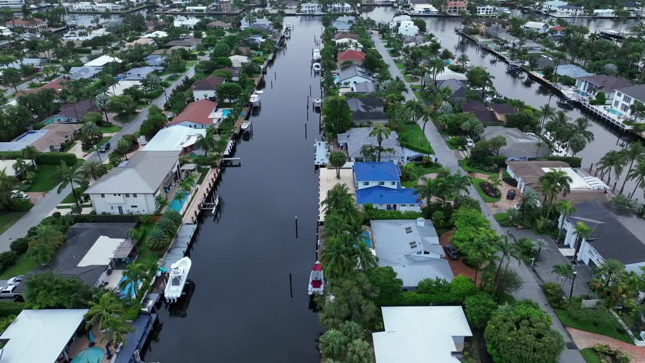 Waterfront residential neighborhood in Fort Lauderdale with canal. Houses with boat docks and lush greenery line the waterway. Peaceful suburban area with scenic canal views and private piers.