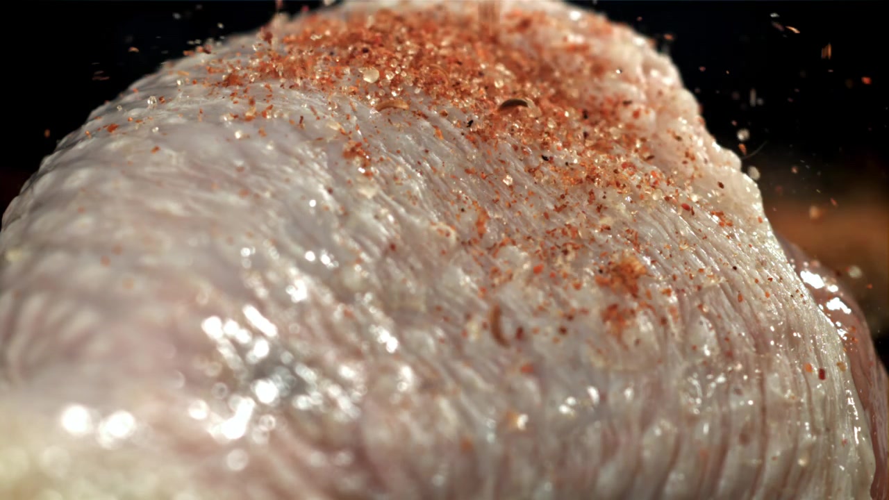 Primo piano di pelle di pollo cruda condita con spezie