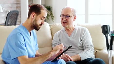 caucasian male nurse talking with a nursing home patient about his health