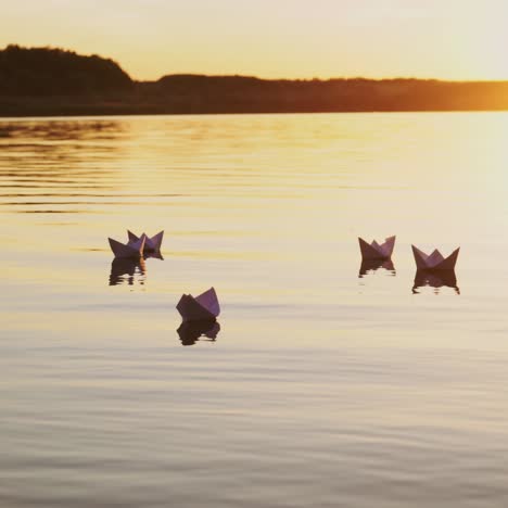 paper boats floating on a river. paper ships in water.