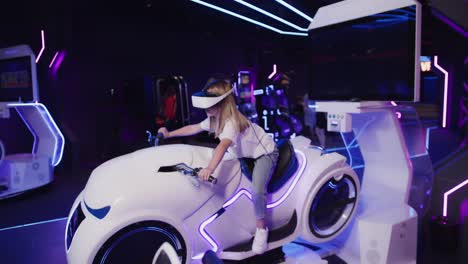 girl playing vr motorcycle simulator in an arcade