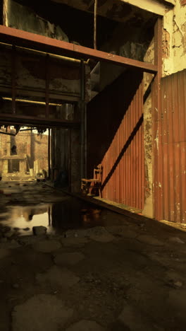 edificio abandonado con silla y puertas metálicas oxidadas