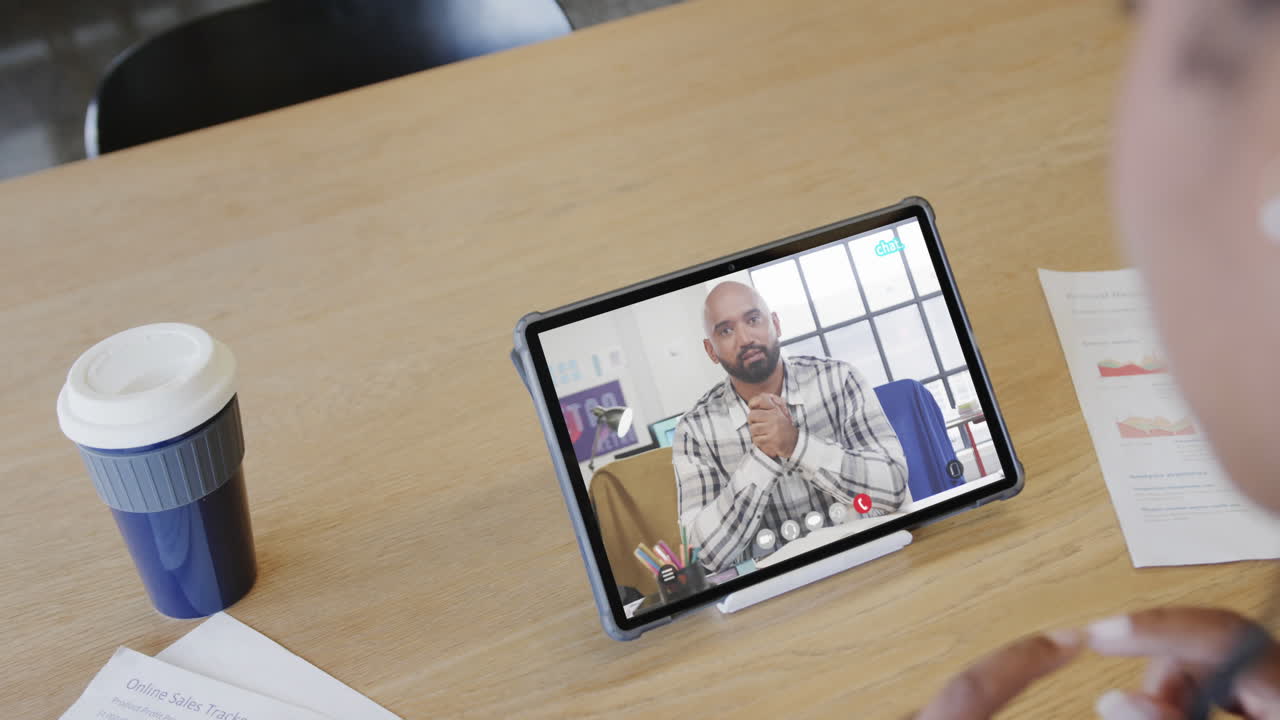 mujer de negocios caucásica en una videollamada con un colega afroamericano en la pantalla