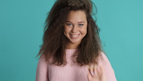 caucasian curly haired woman pointing out to the camera.