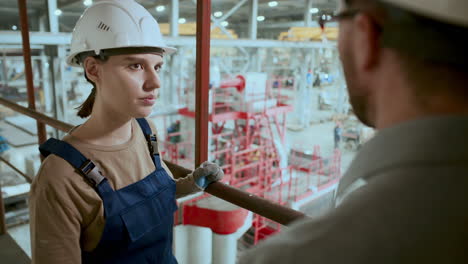 female factory worker discussing production process with engineer