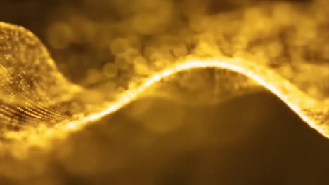 golden particles flow gently, forming captivating waves that dance against a dark backdrop, showcasing intricate patterns and textures in an enchanting display.