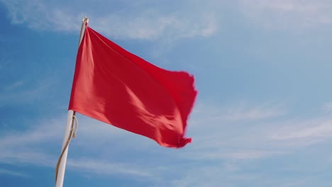 Bandera-Roja-Sobre-Un-Fondo-De-Cielo-Azul