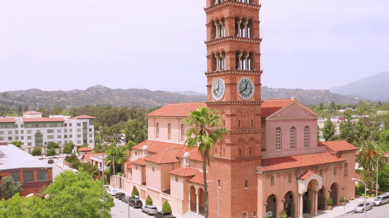 imágenes aéreas de drones en aumento, de la iglesia católica de san andrés campanas del reloj torre hito de la ciudad de pasadena california con tráfico callejero