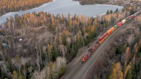 Un-Tren-De-Carga-Largo-Y-Colorido-Que-Tira-De-Una-Gran-Cantidad-De-Contenedores-De-Carga-Y-Envío-A-Través-Del-Escudo-Canadiense