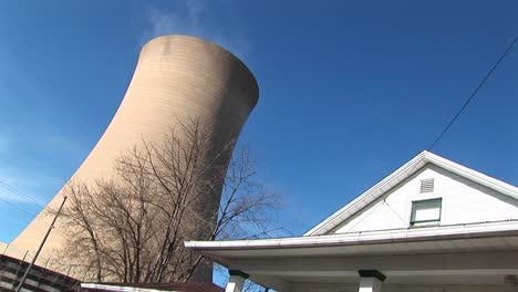 the gigantic cone of a nuclear reactor looms above the roof of a white house