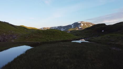 Schöner-Idyllischer-Kleiner-Fluss-Und-Teiche-Mit-Glänzenden-Himmelsreflexionen-Und-Beruhigender-Abendstimmung-Während-Des-Sonnenuntergangs-Am-Berg-Vikafjell-Norwegen-Im-Sommer---Luftfahrt-Ganz-Nah-Am-Boden