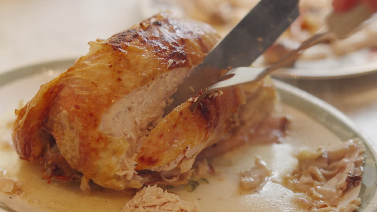 Fast Cutting of Roasted Chicken Joint with Crispy Skin Carved on Plate Ready to Serve to Guests or Customers. Filmed in Natural Light. Traditional British Sunday Lunch Dinner.