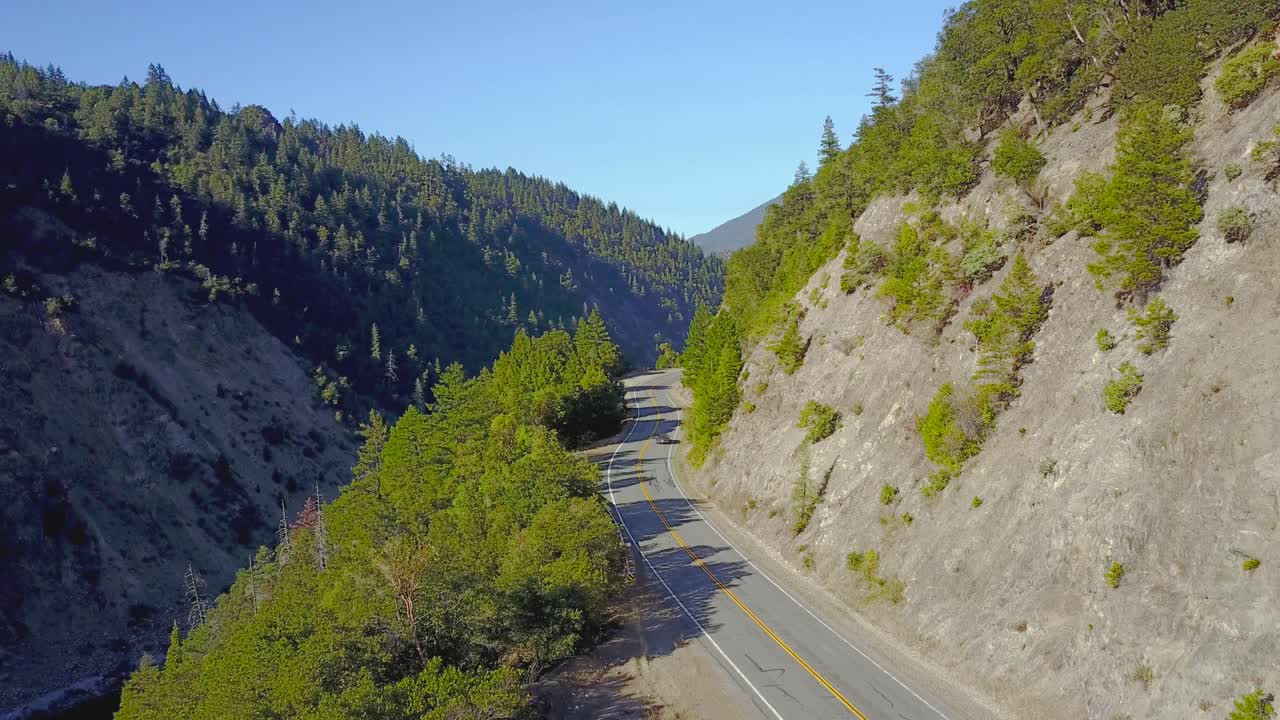 An aerial view of cars moving down desolate road.