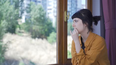 Mujer-Joven-Preocupada-Y-Nerviosa-En-Casa-Mirando-Afuera.