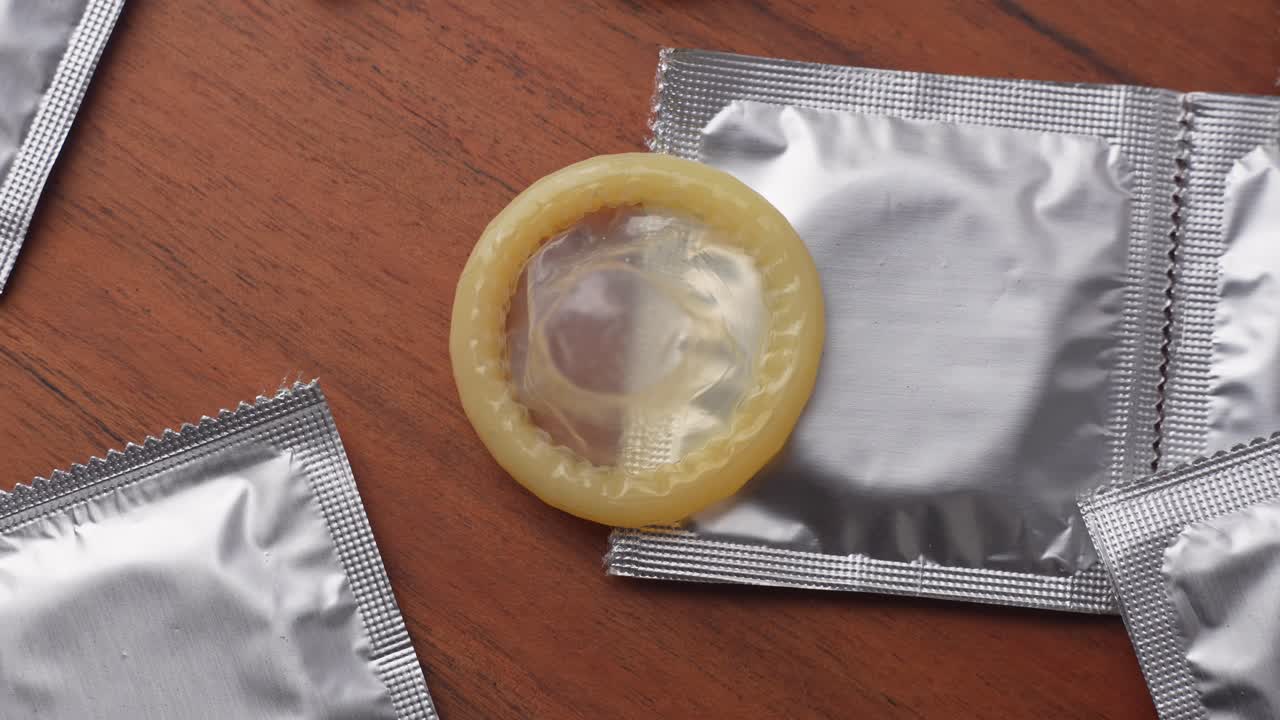 Mostrando pacotes de preservativos em fundo de madeira
