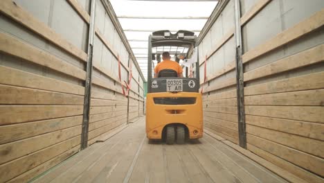 forklift driver transports packaged water bottles in warehouse