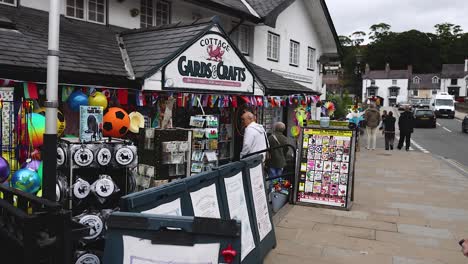 people walking past a colorful craft shop