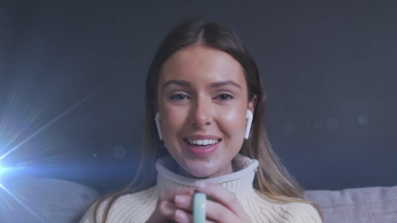 Animazione di punti luce su una donna caucasica sorridente che beve caffè e fa una videochiamata a casa
