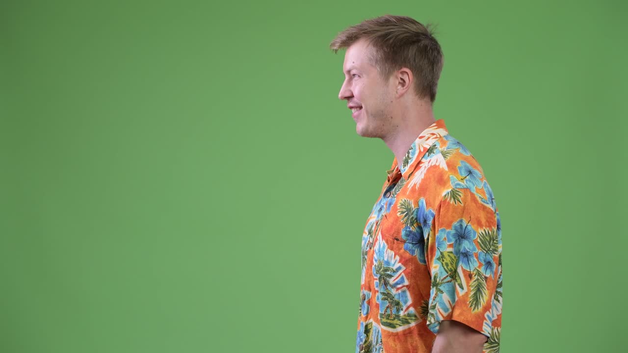 Profile view of young happy handsome tourist man smiling