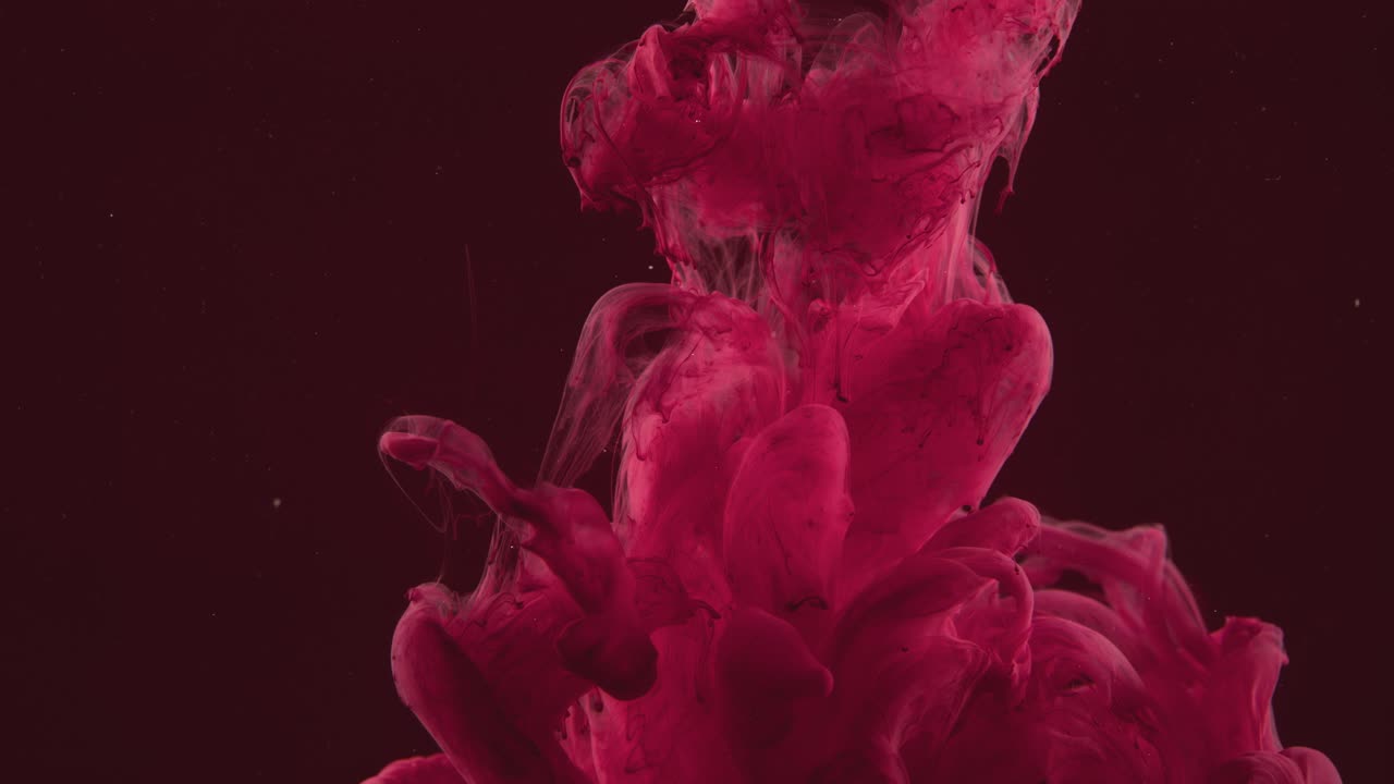 nube de partículas rojas que desciende en el agua