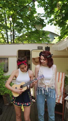 two friends playing ukulele outdoors