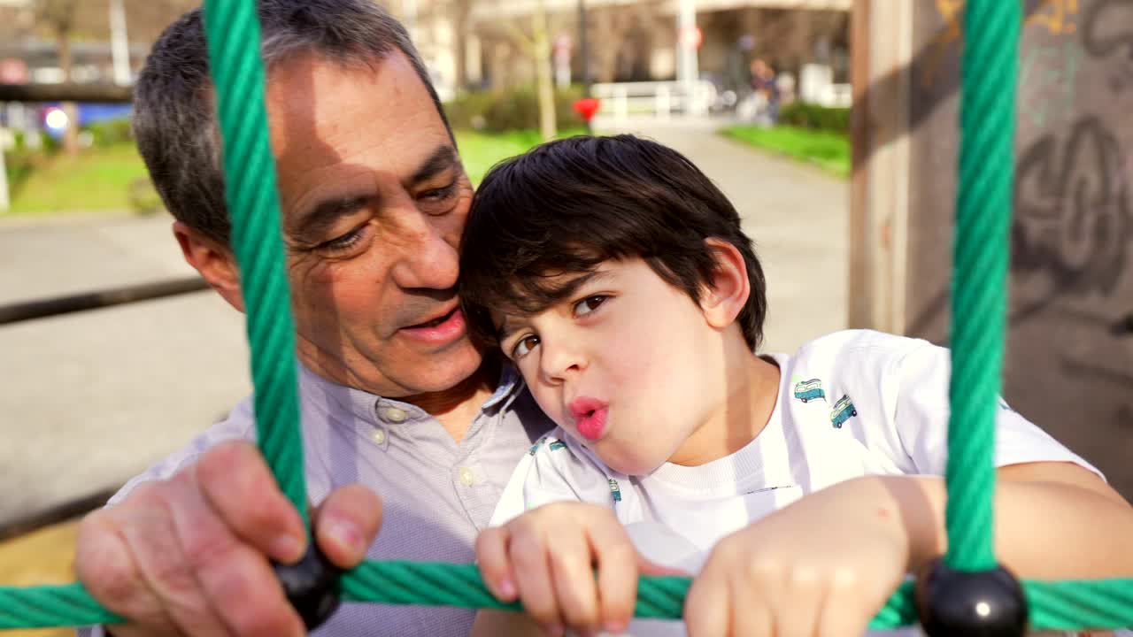 Grandfather and grandson playing together on a playground