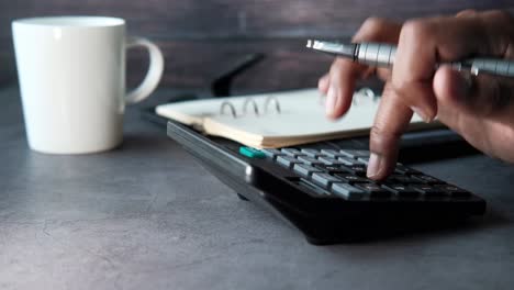 person using calculator and pen