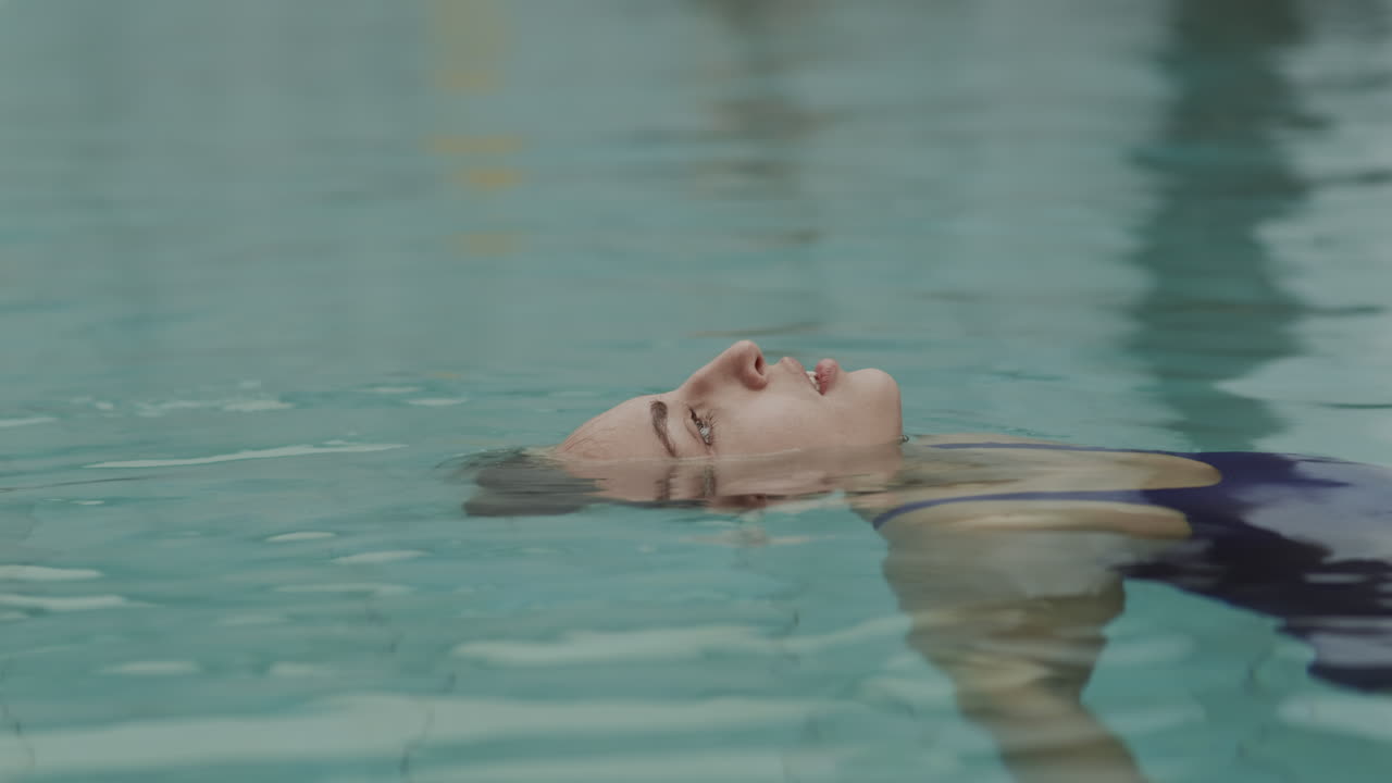 mujer joven relajándose en el agua en la piscina