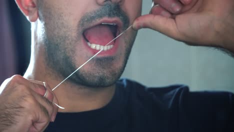 man flossing teeth