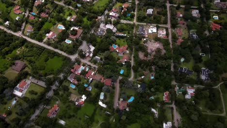 Drone-shot-flying-over-of-the-outskirts-of-the-city-of-Salta,-Argentina-while-panning-up-to-show-the-city-in-the-distance