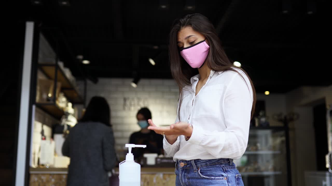 여자 가 커피 에서 손 을 소독 하고 있다