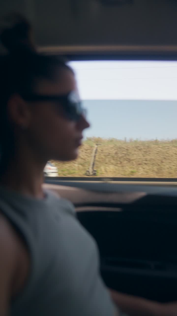 Woman on a road trip, looking out the car window