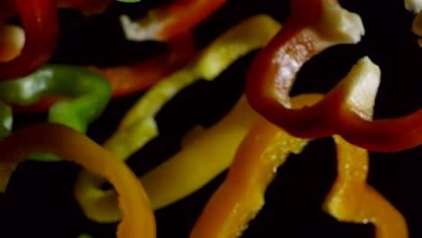 trozos de pimientos coloridos sobre un fondo negro