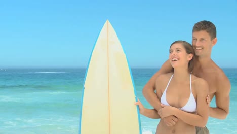 una pareja linda con una tabla de surf