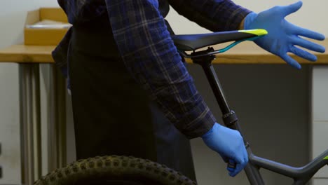 Man-repairing-bicycle-seat-in-workshop-4k