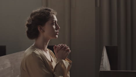 young caucasian woman praying in church