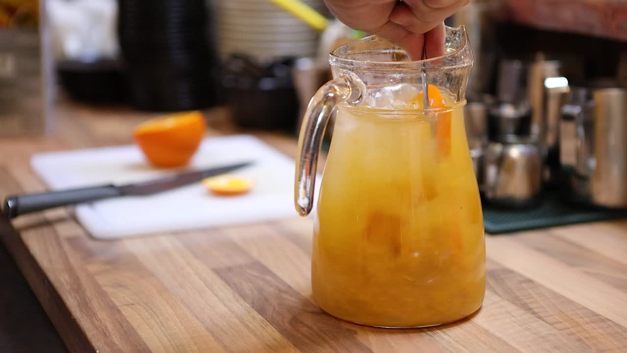 Barista che prepara una limonata nella brocca mescolandola.