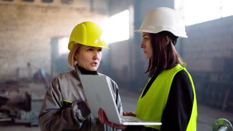 Two-workmates-talking-at-the-factory