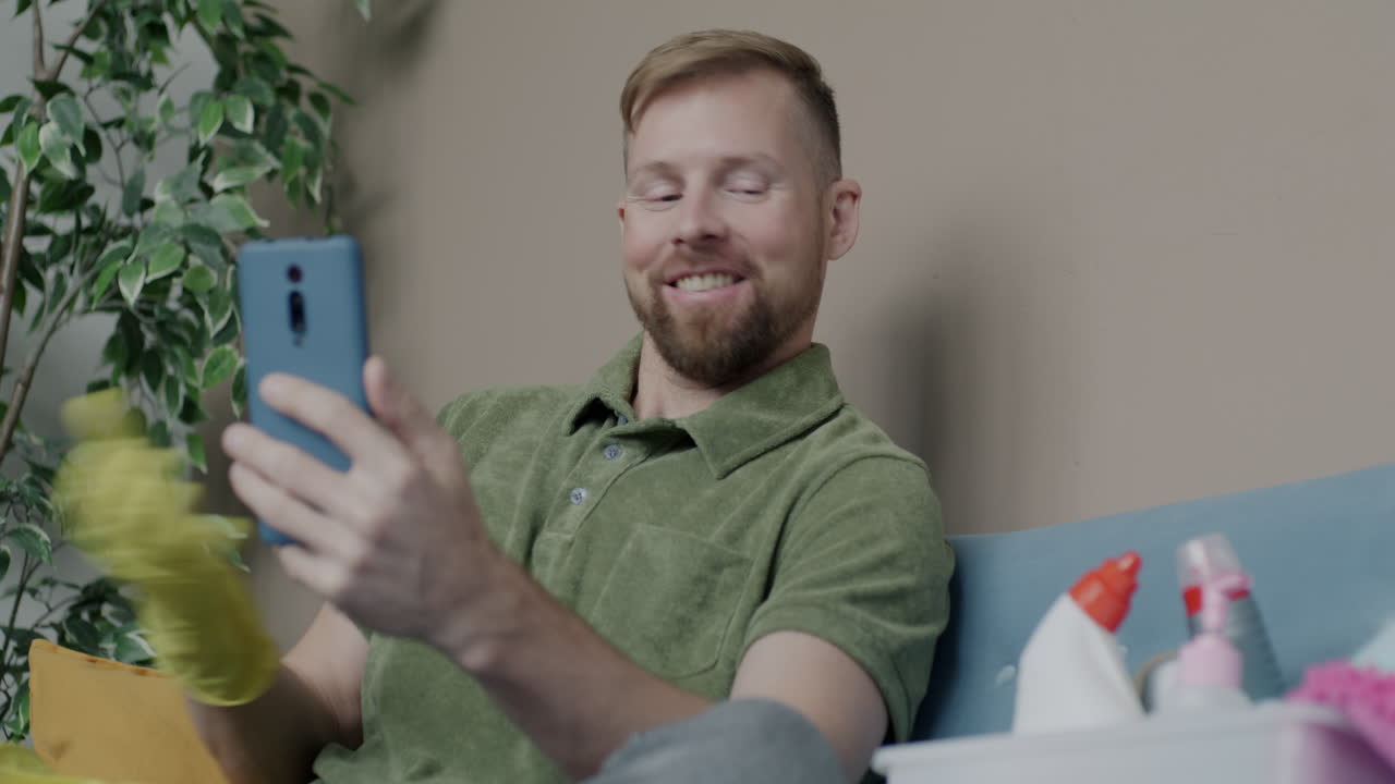 Man cleaning his home by video call